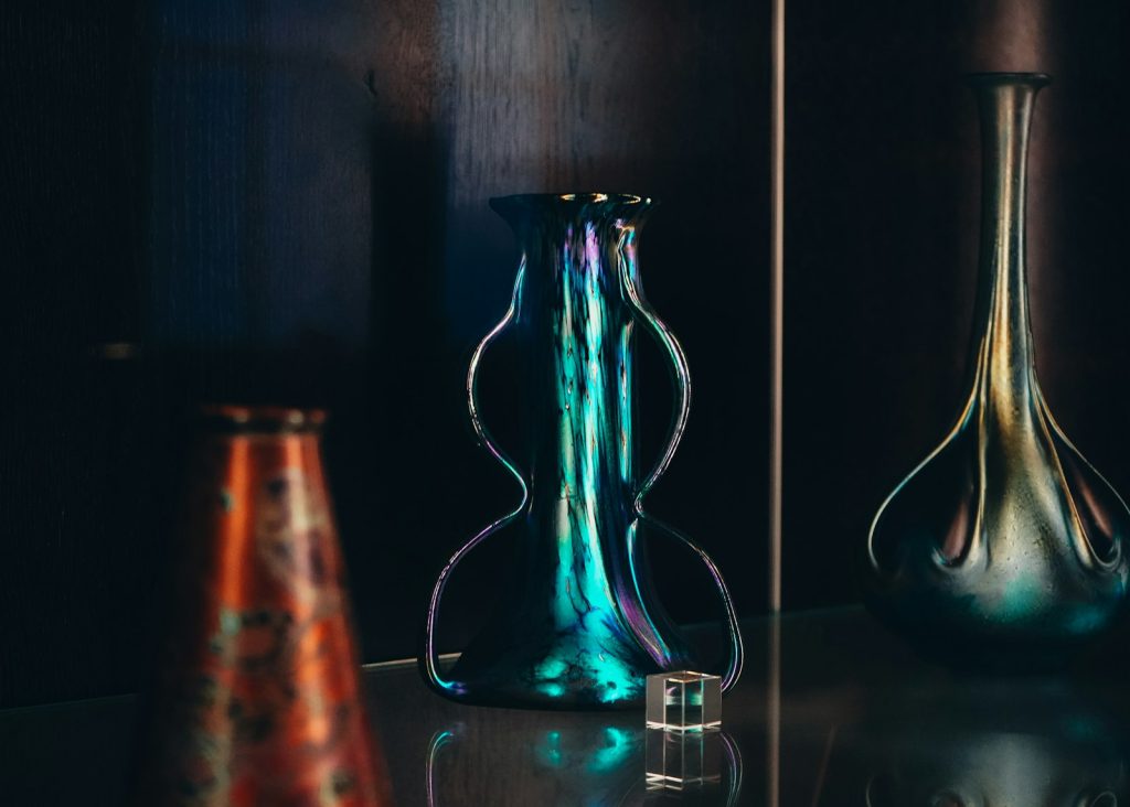 Three colorful glass vases on a dark background.